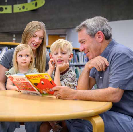 Aaron Lieberman reading with children and an educator